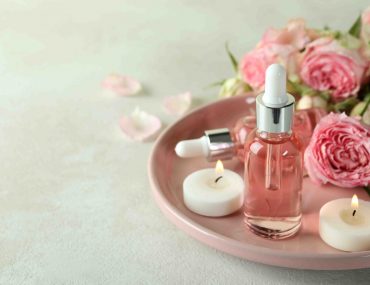 Skin care concept with essential rose oil on white textured table